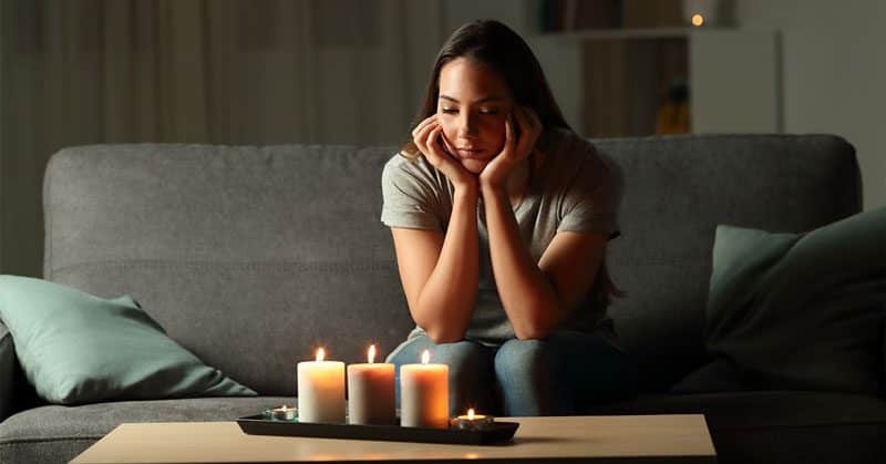 Girl sits through a power outage with candles because heating systems, portable heaters, and other seasonal devices put a significant strain on a home’s electrical system.